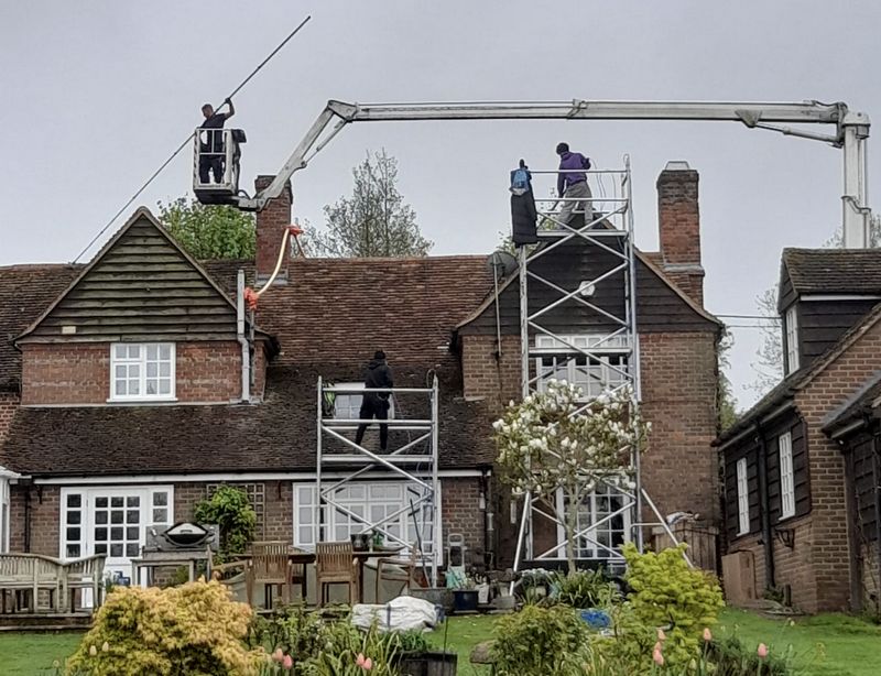 The Roof Moss Cleaners using cherry picker and scaffolding to clean roof safely and professionally in Cranleigh, Surrey